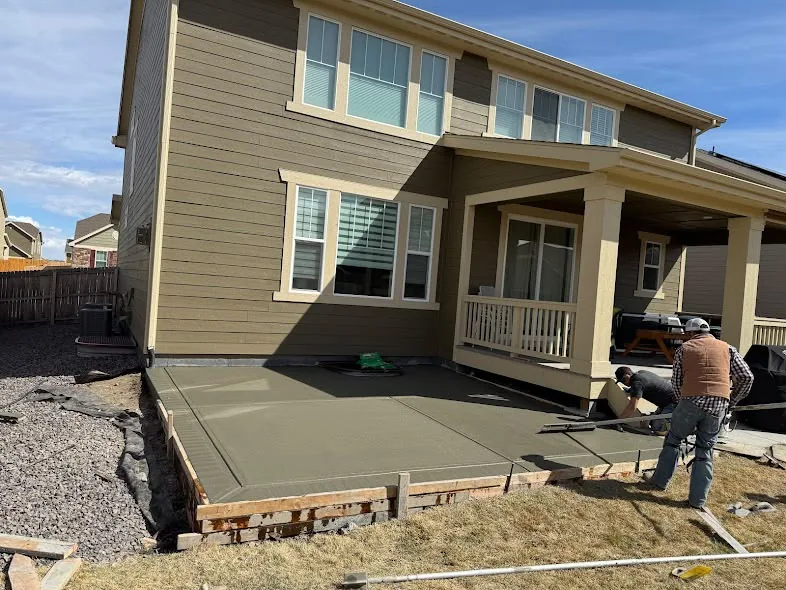 New concrete patio poured next to a covered porch