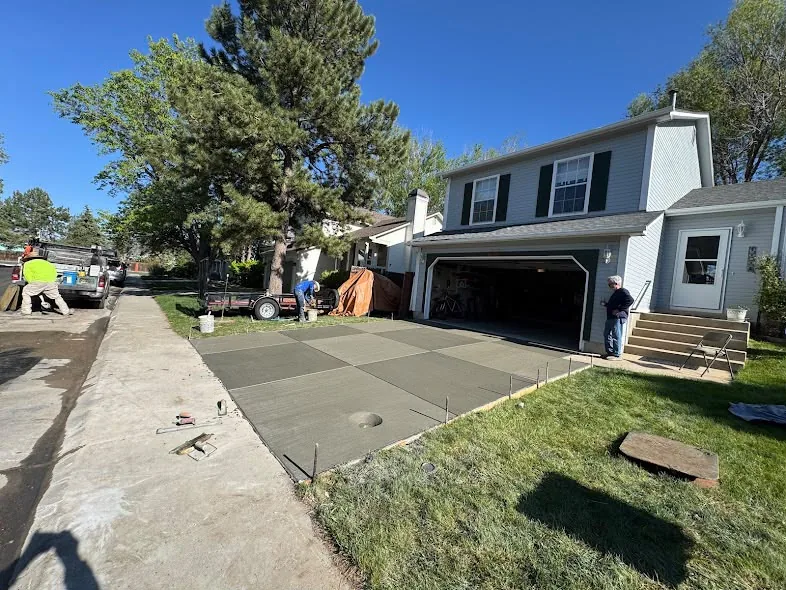 Concrete driveway replacement in front of a two-story home