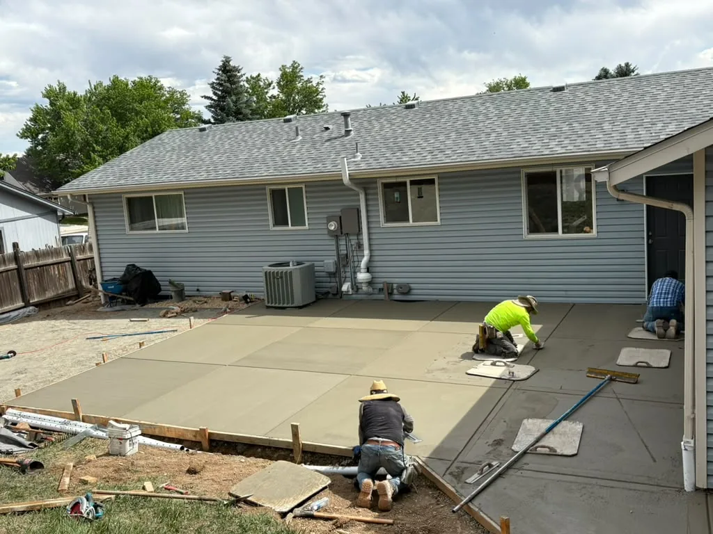 Hand-finishing a new concrete patio extension
