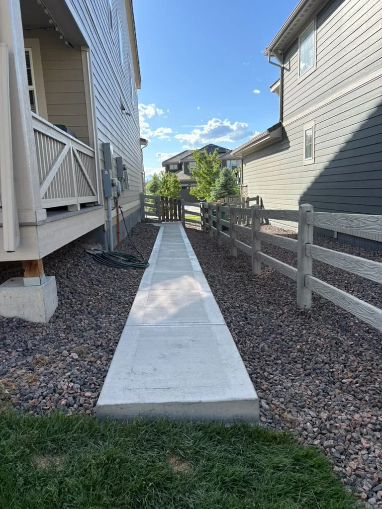 Finished concrete side-yard walkway between rock beds
