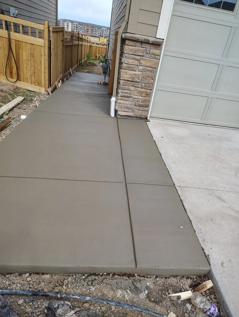 Freshly poured side walkway next to a garage